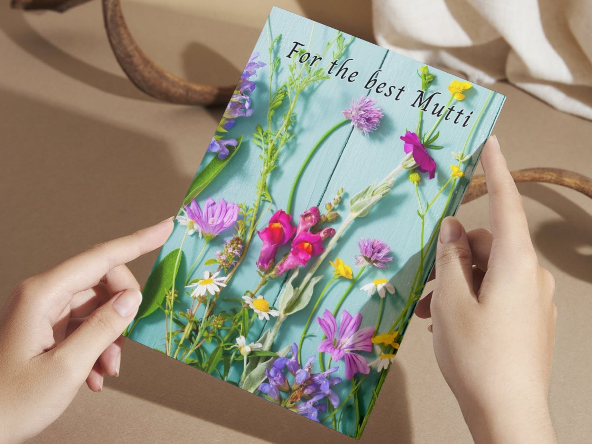 Floral card held by hands with a decorative background